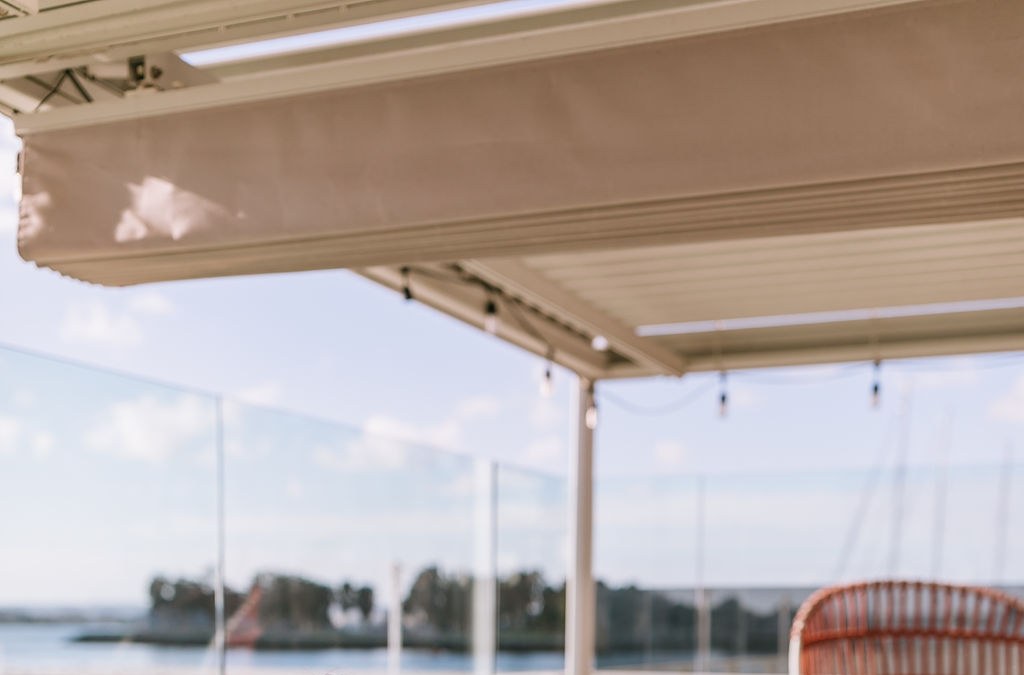 String lights strung under the patio canopy with the water beyond.